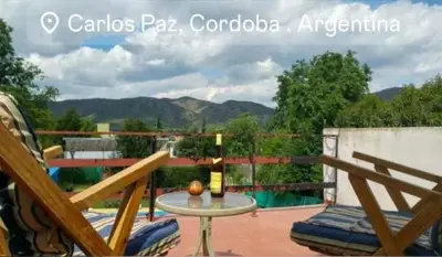 a patio with a table and chairs on a balcony at Cabaña A Mí Manera in Villa Carlos Paz