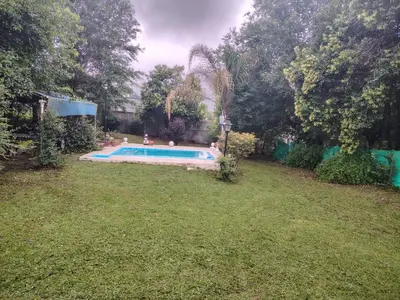 a swimming pool in a yard with people in it at Cabaña A Mí Manera in Villa Carlos Paz
