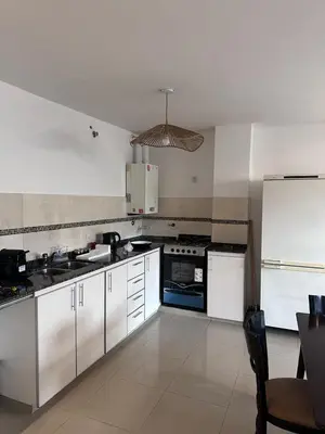 a kitchen with white cabinets and a blue stove at Depto centro in Villa Carlos Paz