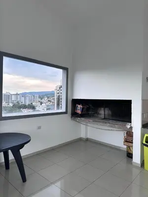 a living room with a fireplace and a table at Depto centro in Villa Carlos Paz