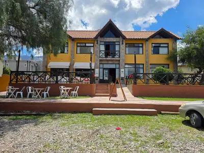 a yellow house with tables and chairs in front of it at Merlo Trail Lodge in Merlo