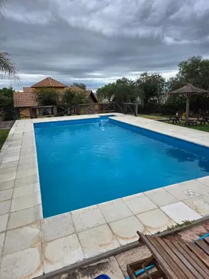 a swimming pool with blue water in a yard at Merlo Trail Lodge in Merlo