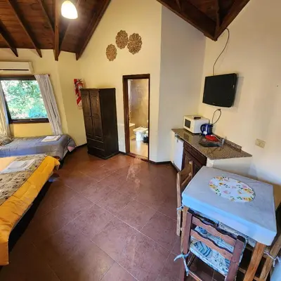 a room with a bed and a table and a tv at Merlo Trail Lodge in Merlo