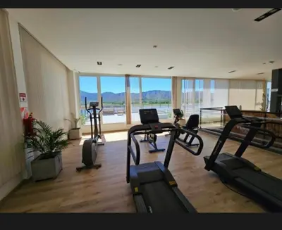 a gym with several treadmills and a large window at Veneto village depto in Villa Parque Siquiman