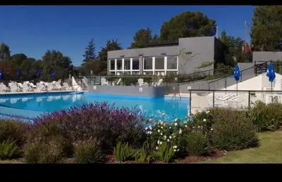 a large swimming pool in front of a building at Veneto village depto in Villa Parque Siquiman