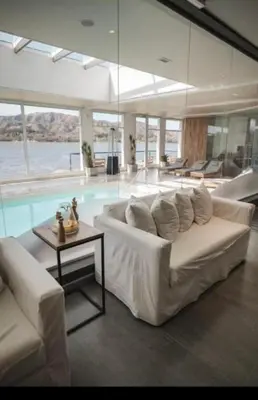 a living room with a white couch and a pool at Veneto village depto in Villa Parque Siquiman
