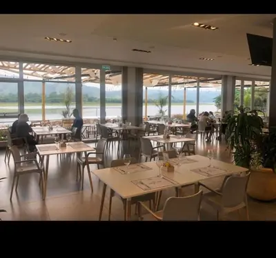 a restaurant with tables and chairs with people sitting at them at Veneto village depto in Villa Parque Siquiman