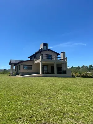 a large house with a green field in front of it at Casa de campo El Colibrí in Villa Ciudad Parque