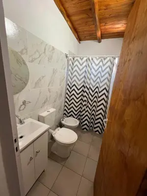 a bathroom with a toilet and a shower curtain at Monoambientes Pitu! in Villa Cura Brochero