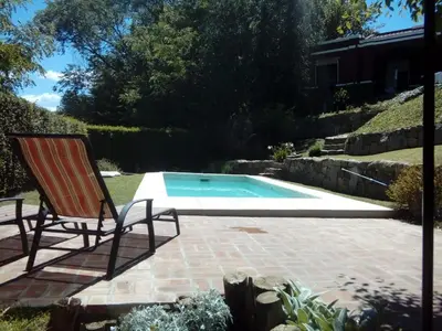 a patio with a chair and a swimming pool at La Morada in Mina Clavero