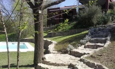 a yard with a swimming pool and a tree at La Morada in Mina Clavero
