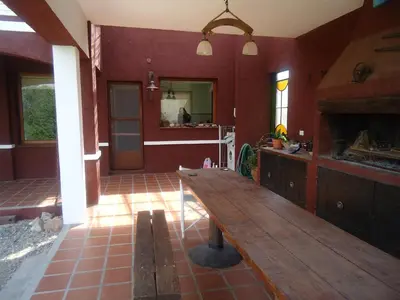a kitchen with a wooden table in the middle of a room at La Morada in Mina Clavero