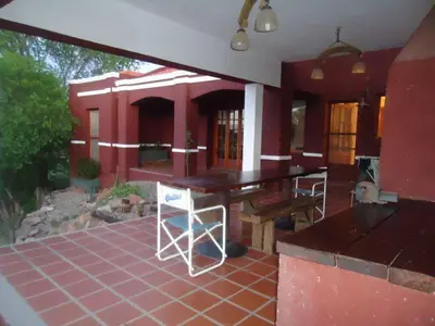 a house with a table and chairs on a patio at La Morada in Mina Clavero