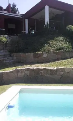 a large swimming pool in front of a house at La Morada in Mina Clavero
