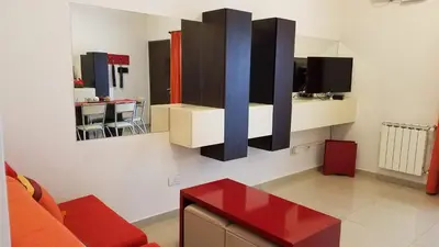 a living room with a red table and a mirror at Torre Myng in Villa Carlos Paz