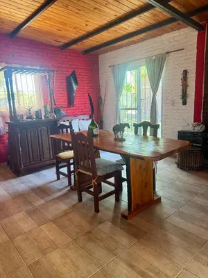 a dining room with a wooden table and chairs at Miraflores in Santa Rosa de Calamuchita
