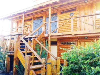 a wooden house with a wooden staircase leading up to it at Ensueño Cabañas in Los Reartes