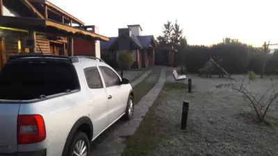 a white car parked in front of a house at Ensueño Cabañas in Los Reartes