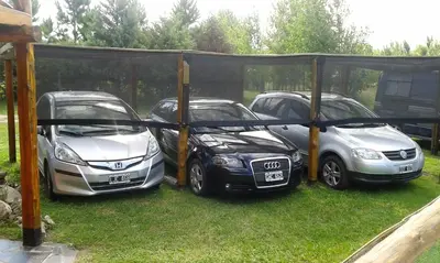 a group of three cars parked under a gazebo at Ensueño Cabañas in Los Reartes