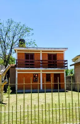 a house with a fence in front of it at Casa, Rio y Familia Mina Clavero in Mina Clavero