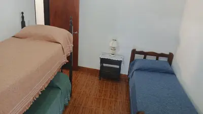 a bedroom with two beds and a side table at Casa, Rio y Familia Mina Clavero in Mina Clavero