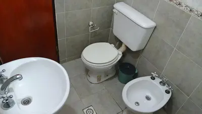 a bathroom with a white toilet and a sink at Casa, Rio y Familia Mina Clavero in Mina Clavero