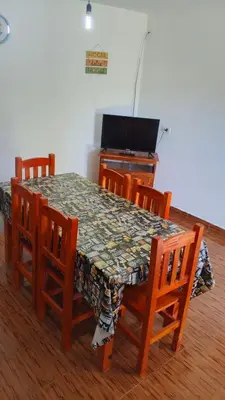 a dining room with a table and chairs and a television at Casa, Rio y Familia Mina Clavero in Mina Clavero