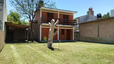 a tree in a yard in front of a house at Casa, Rio y Familia Mina Clavero in Mina Clavero