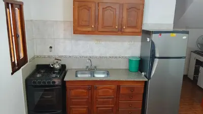 a kitchen with a sink and a refrigerator at Casa, Rio y Familia Mina Clavero in Mina Clavero