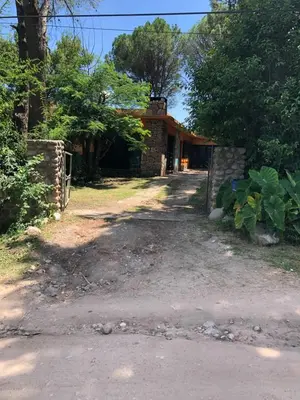 a house with a dirt road in front of it at Kuku hostel in Las Rabonas