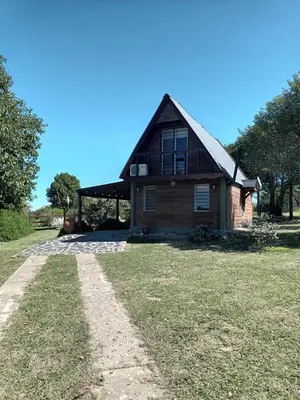 an old house sitting on top of a grass field at Cabaña Buena Vista Los Reartes in Los Reartes