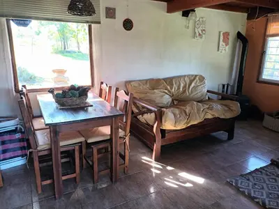a living room with a table and a couch at Cabaña Buena Vista Los Reartes in Los Reartes