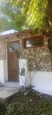a stone house with a door and a stone wall at La casita de Mila in Amboy