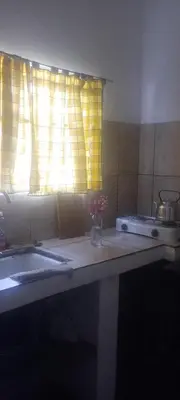 a kitchen counter with a sink and a window at La casita de Mila in Amboy