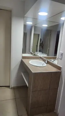 a bathroom with a sink and a large mirror at Apart Playas de Oro in Villa Carlos Paz