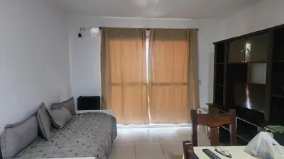 a living room with a couch in front of a window at Apart Playas de Oro in Villa Carlos Paz
