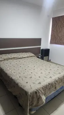 a bed sitting in a room with a bedskirtspectspectspects at Apart Playas de Oro in Villa Carlos Paz