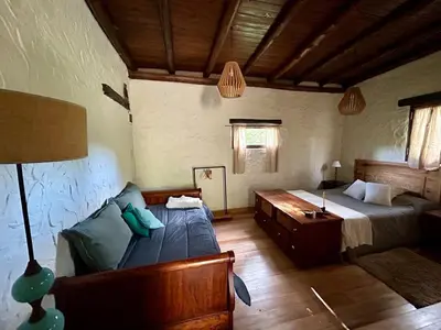 a bedroom with a bed and a couch in a room at Iris,Tiny house en Las Calles, Traslasierra in Las Calles