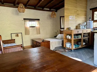 a room with a bedroom with a bed and a table at Iris,Tiny house en Las Calles, Traslasierra in Las Calles