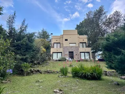 a large house in the middle of a yard at La Morondanga in Villa Yacanto