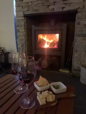 a table with glasses of wine and cheese in front of a fireplace at La Morondanga in Villa Yacanto