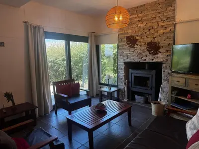 a living room with a table and a fireplace at La Morondanga in Villa Yacanto