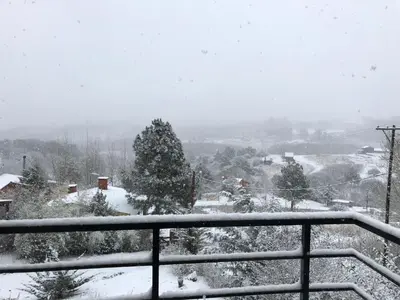 a snow covered view of a town with trees at La Morondanga in Villa Yacanto