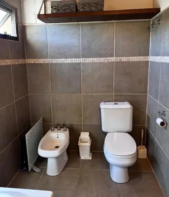 a bathroom with a toilet and a sink at La Morondanga in Villa Yacanto
