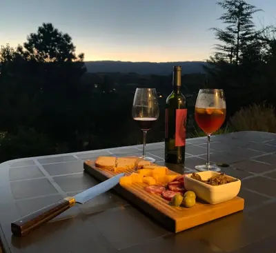 a table with a bottle of wine and two glasses at La Morondanga in Villa Yacanto