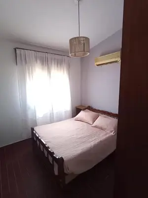 a bedroom with a bed with a window and a chandelier at chalet los condores in Villa Carlos Paz