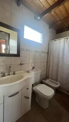 a bathroom with a sink and a toilet and a mirror at Complejo turistico Alto del Valle in Villa Carlos Paz