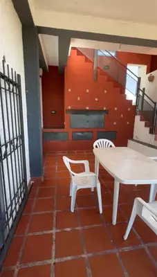 a room with a table and chairs and stairs at Complejo turistico Alto del Valle in Villa Carlos Paz