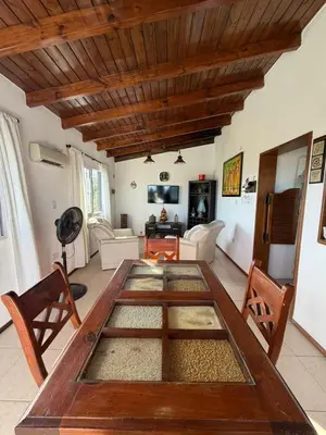 a living room with a large wooden table and chairs at Complejo turistico Alto del Valle in Villa Carlos Paz