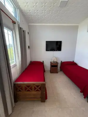a bedroom with two beds and a flat screen tv at Complejo turistico Alto del Valle in Villa Carlos Paz